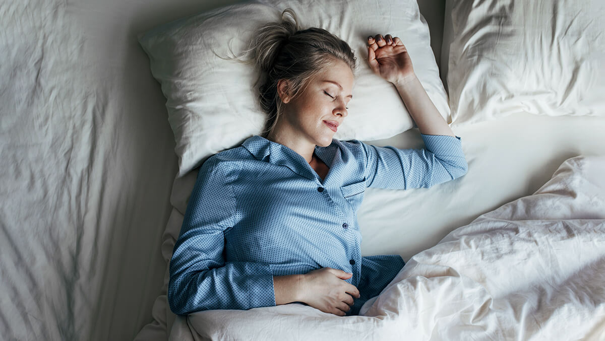 Frau schläft entspannt im Bett