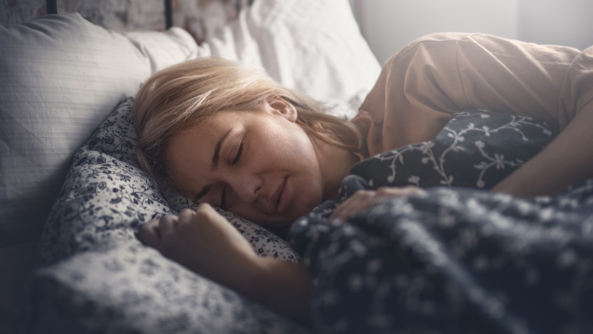 Schlafende Frau liegt im Bett