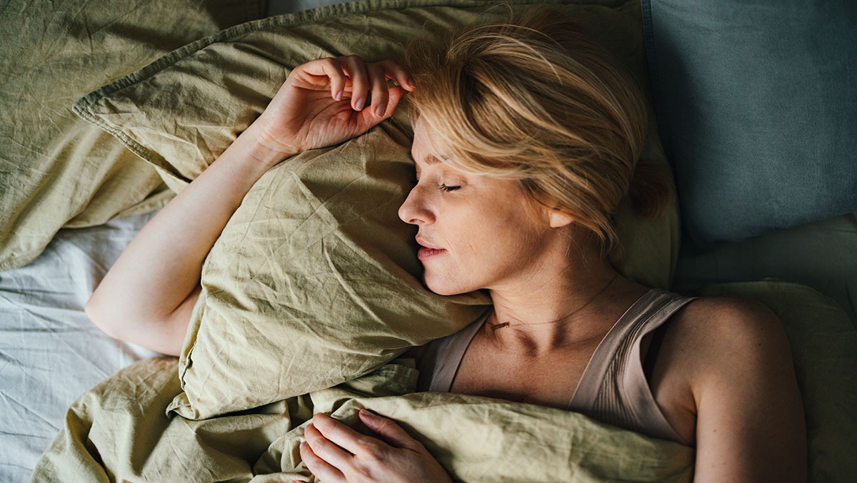 Junge Frau liegt schlafend im Bett